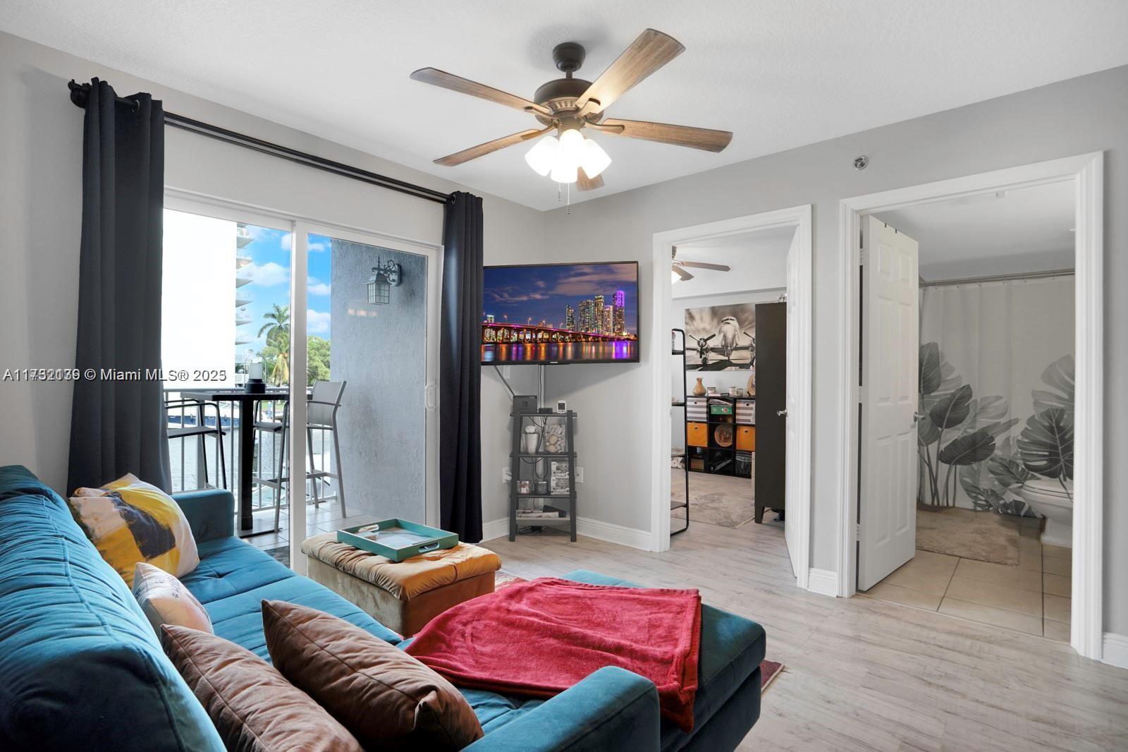 2475 Northwest 16th St Road, Unit 216 Miami, FL 33125 - Photo 4 of 16 a living room with furniture and a chandelier