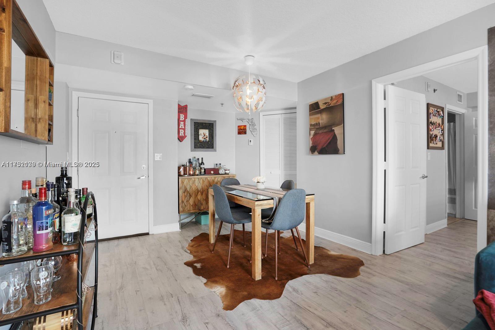 2475 Northwest 16th St Road, Unit 216 Miami, FL 33125 - Photo 6 of 16 a view of a dining room with furniture and wooden floor