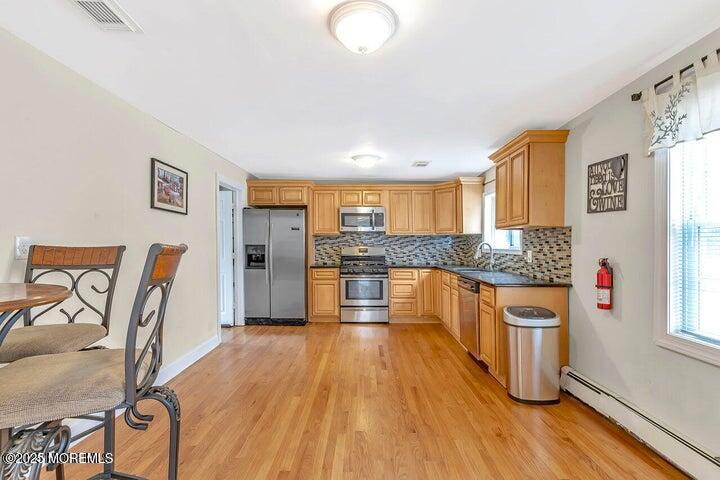 164 Jackson Street Matawan, NJ 07747 - Photo 5 of 27 a large kitchen with stainless steel appliances granite countertop a stove a sink dishwasher and a refrigerator with wooden floor