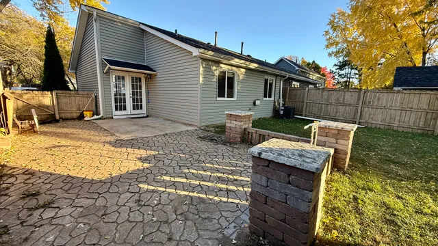 a view of a patio with table and chairs with wooden fence