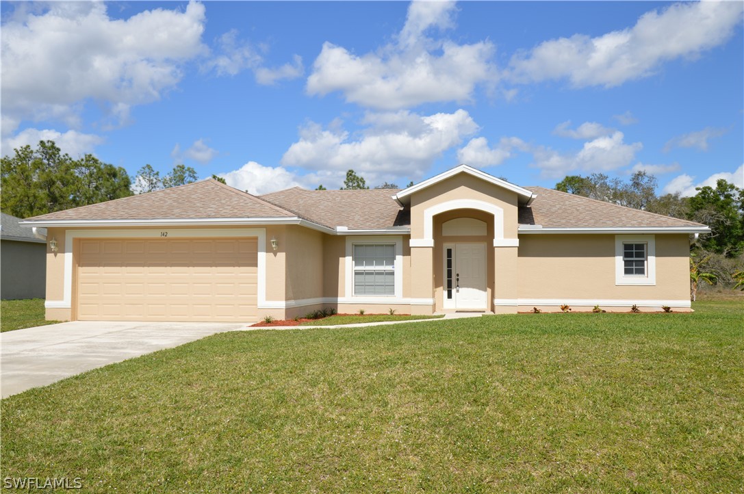 a front view of a house with a garden and yard