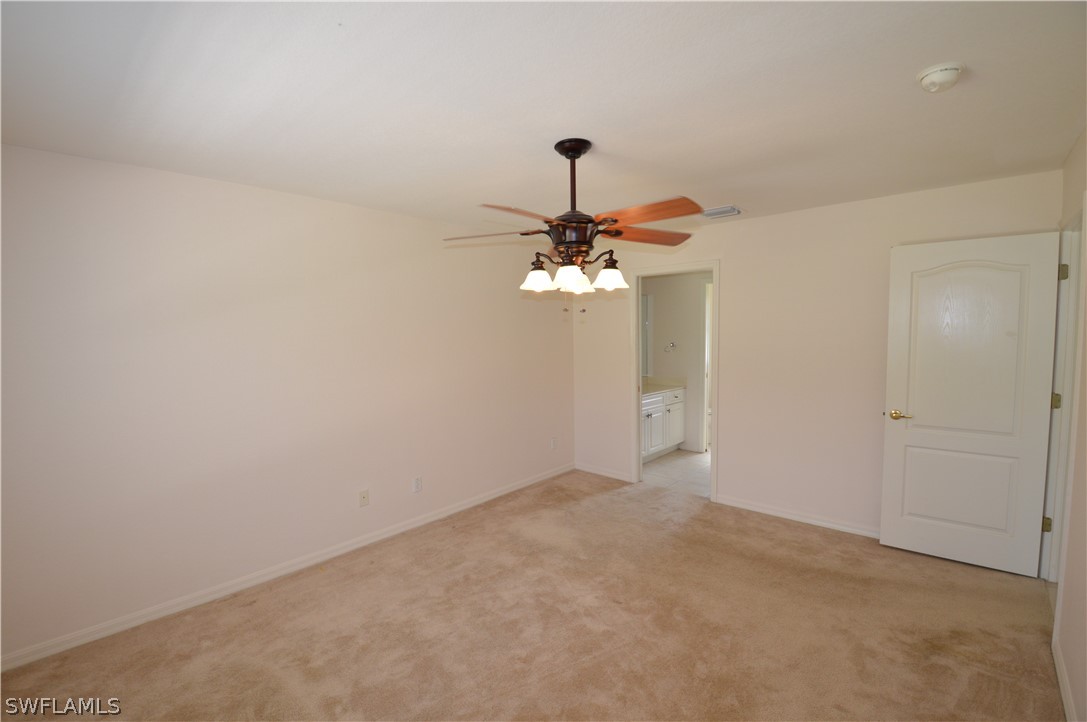 142 Ridgemont Drive Lehigh Acres, FL 33972 - Photo 14 of 15 a view of a chandelier fan in a room