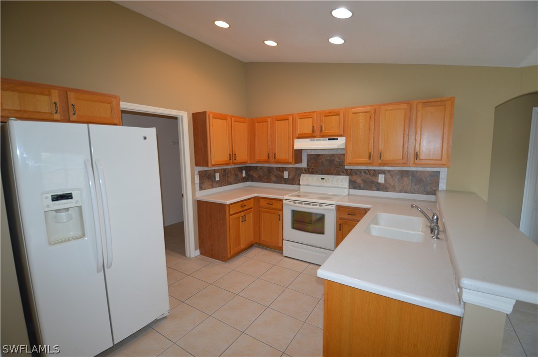 142 Ridgemont Drive Lehigh Acres, FL 33972 - Photo 6 of 15 a kitchen with a refrigerator sink and stove