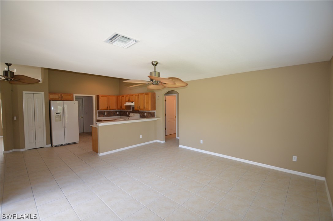 142 Ridgemont Drive Lehigh Acres, FL 33972 - Photo 7 of 15 a view of a kitchen with a sink and refrigerator