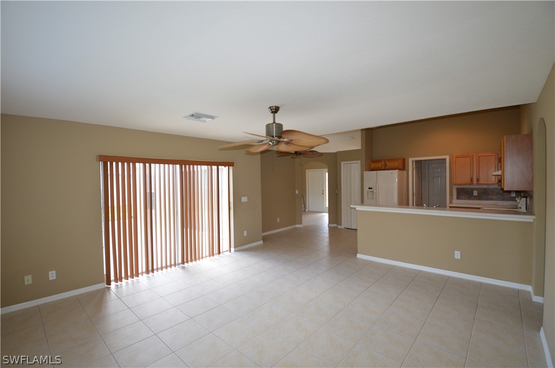 142 Ridgemont Drive Lehigh Acres, FL 33972 - Photo 8 of 15 an empty room with chandelier fan and windows