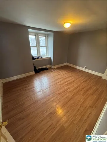 a view of empty room with wooden floor
