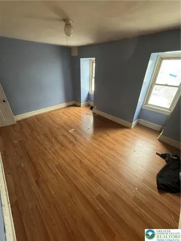 a view of an empty room with wooden floor