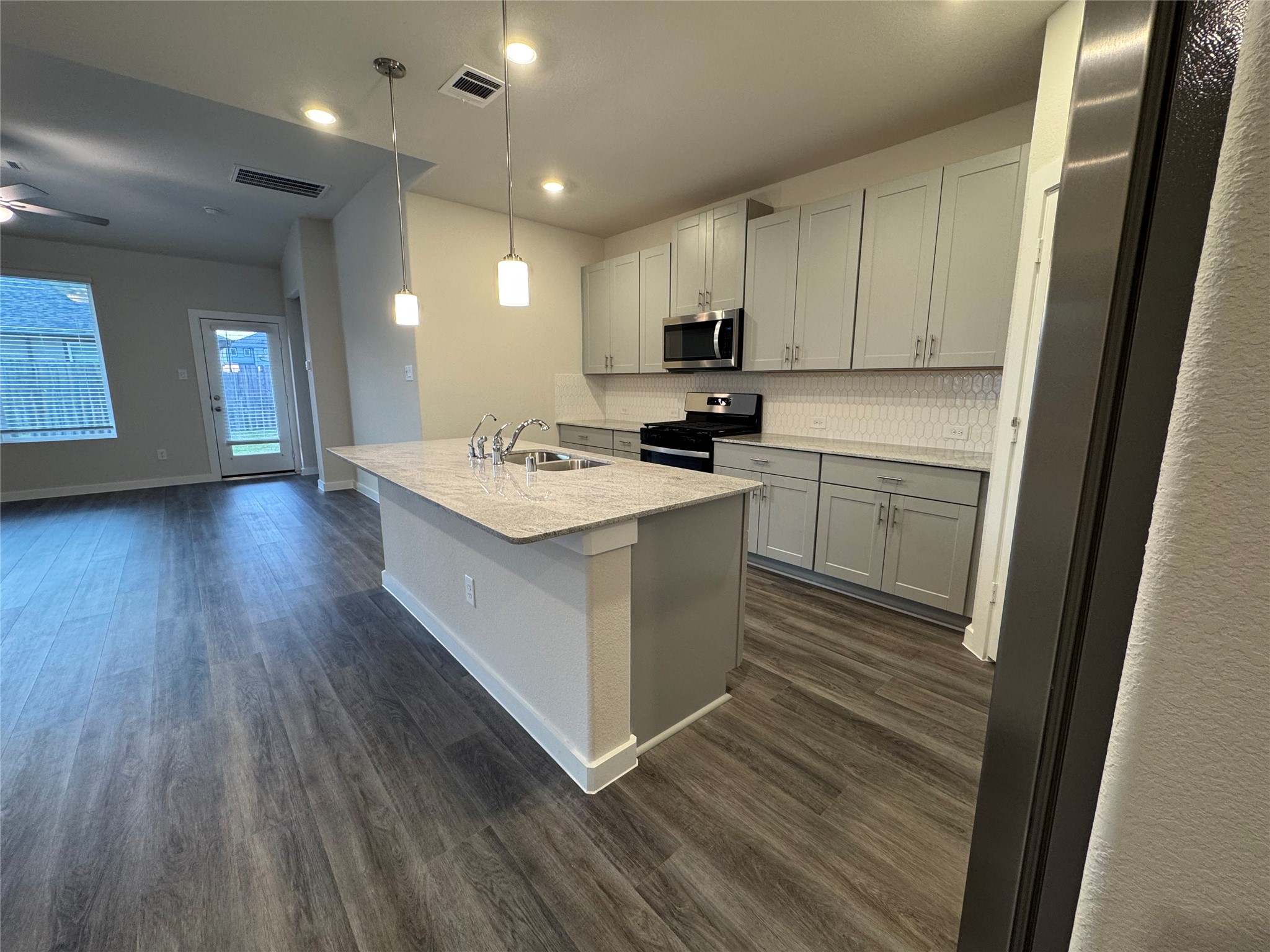 18731 Frost Ridge Drive Crosby, TX 77532 - Photo 7 of 26 a kitchen with a sink a stove cabinets and wooden floor