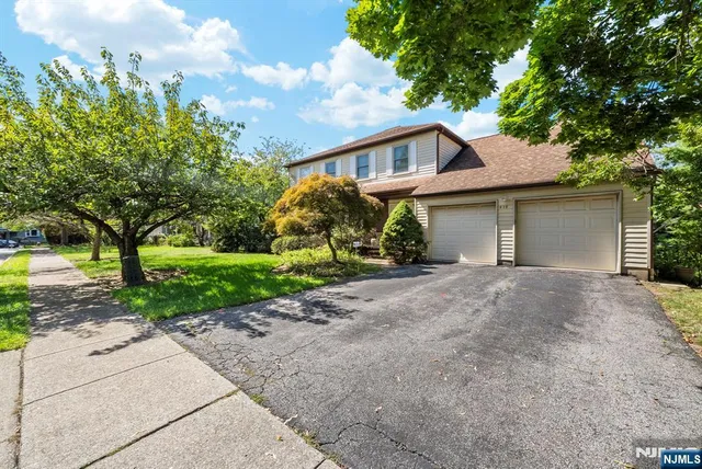 a view of a house with a yard and large tree