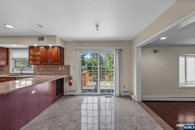 a large kitchen with stainless steel appliances granite countertop a sink and cabinets