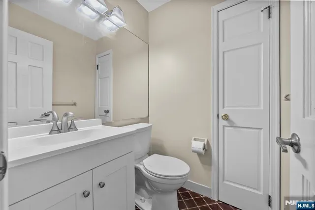 a bathroom with a toilet a sink a mirror and vanity