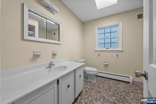 a bathroom with a sink a toilet and a mirror