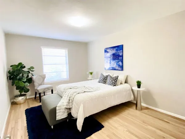 a bedroom with a bed and a potted plant