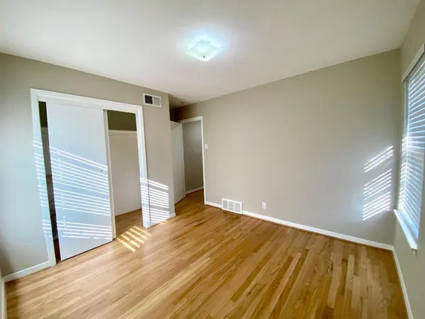 a view of empty room with wooden floor