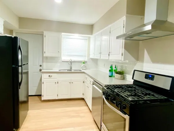 a kitchen with a stove a sink and a refrigerator