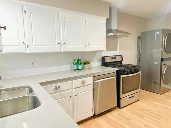 a kitchen with white cabinets and white appliances