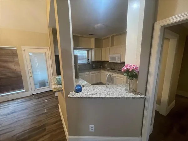 a bathroom with a granite countertop sink a mirror and shower