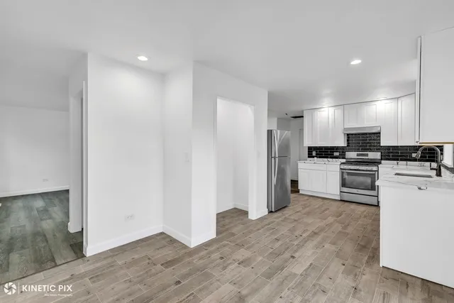 a kitchen with white cabinets and stainless steel appliances