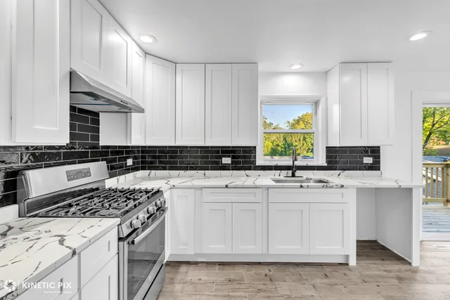 a kitchen with a sink a stove cabinets and a window