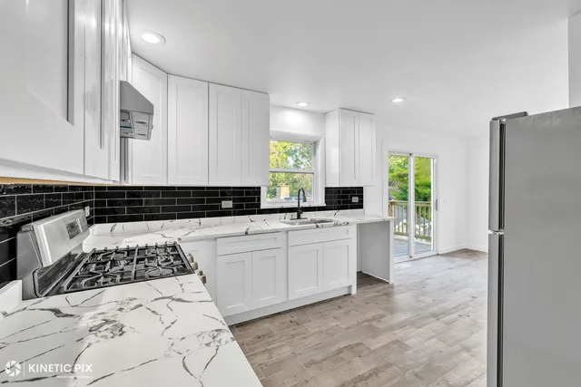 a kitchen with a refrigerator and a stove top oven