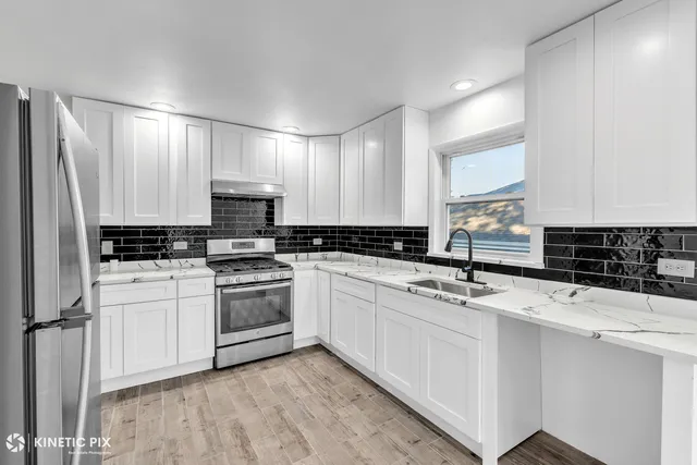 a kitchen with stainless steel appliances a sink stove and cabinets
