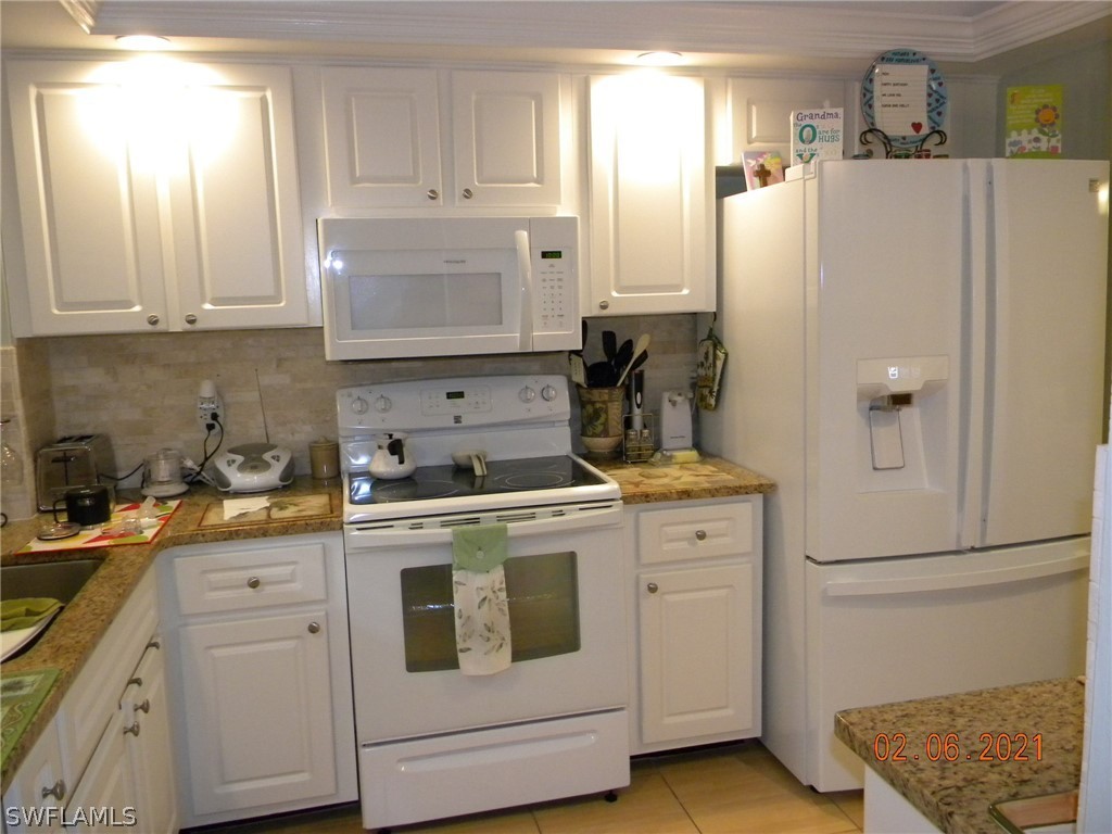 2121 Collier Avenue, Unit 102 Fort Myers, FL 33901 - Photo 11 of 28 a kitchen with white cabinets and white appliances