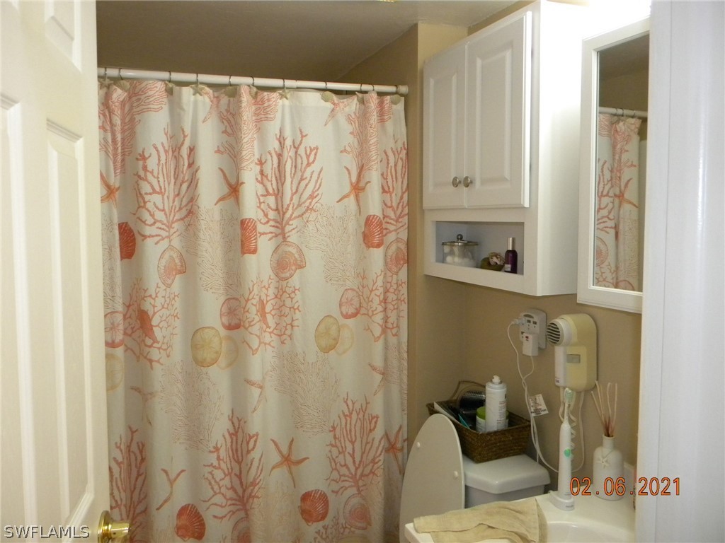 2121 Collier Avenue, Unit 102 Fort Myers, FL 33901 - Photo 19 of 28 a bathroom with a shower curtain and a sink