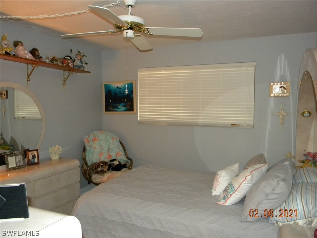 2121 Collier Avenue, Unit 102 Fort Myers, FL 33901 - Photo 3 of 28 a bedroom with a bed and a chandelier