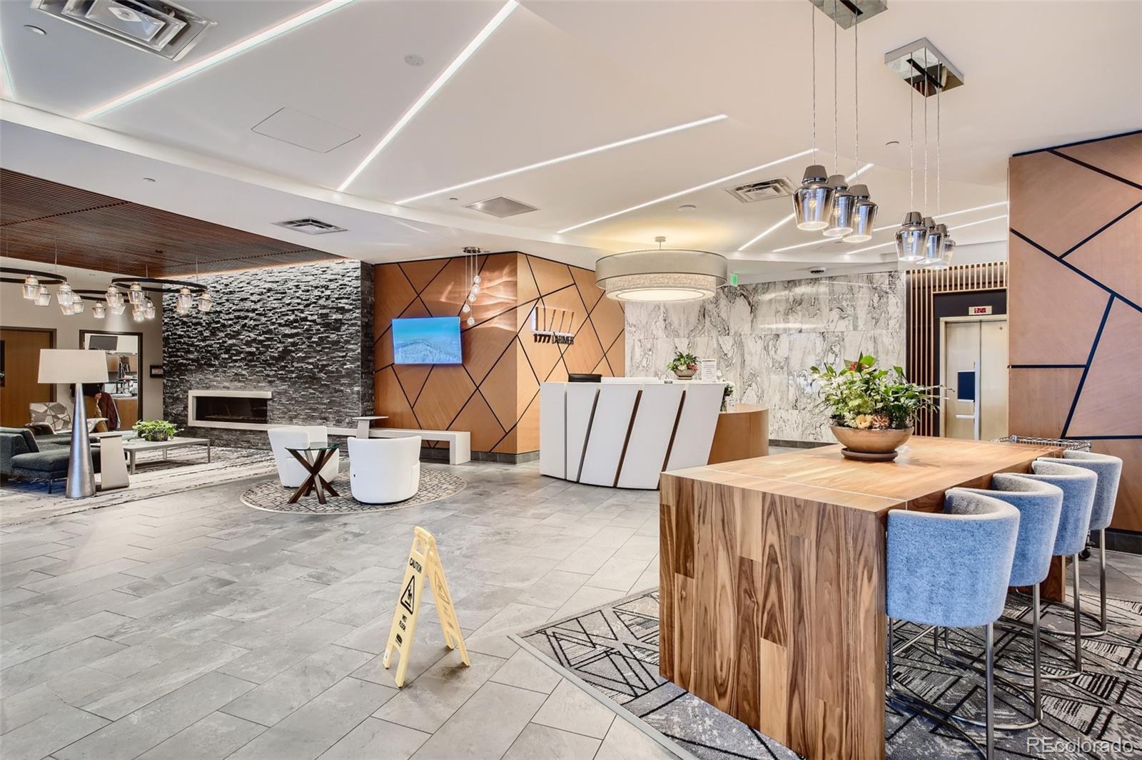 1777 Larimer Street, Unit 710 Denver, CO 80202 - Photo 18 of 28 a living room with furniture a fireplace and chandelier