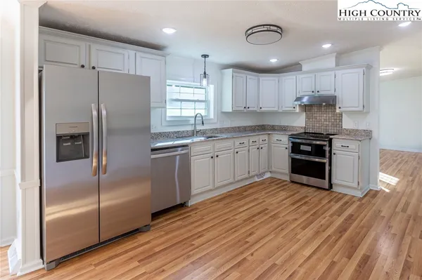 a kitchen with stainless steel appliances granite countertop a stove a sink and a refrigerator