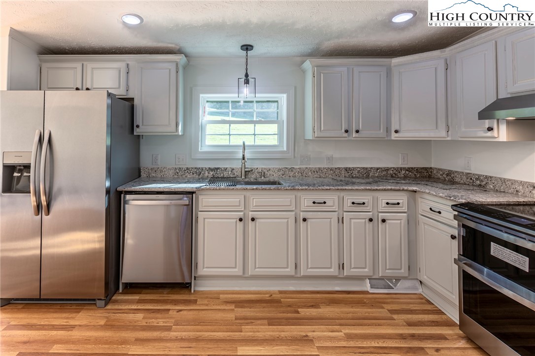 101 Beau Rivage Drive Crumpler, NC 28617 - Photo 16 of 47 a kitchen with granite countertop a sink stainless steel appliances and cabinets