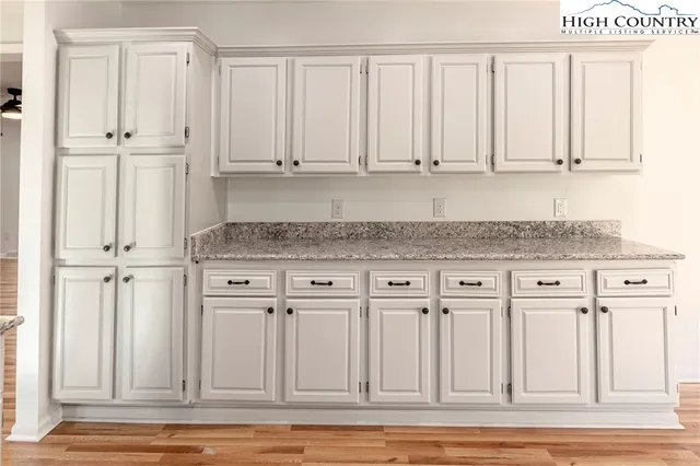 a white kitchen with granite countertop white cabinets and a granite countertops