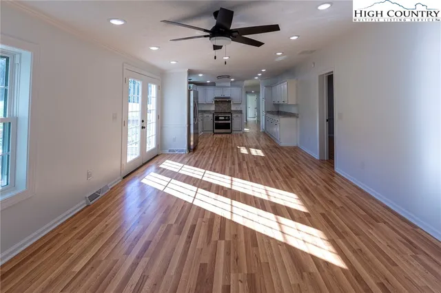 a view of a living room a hallway and a kitchen with wooden floor