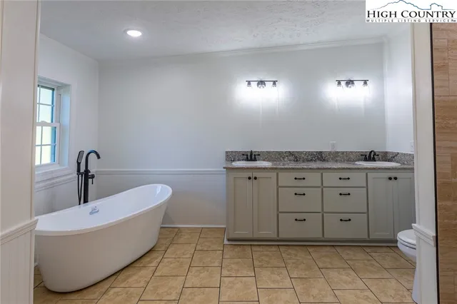 a spacious bathroom with a granite countertop sink and mirror
