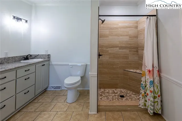 a bathroom with a granite countertop toilet a sink and a shower