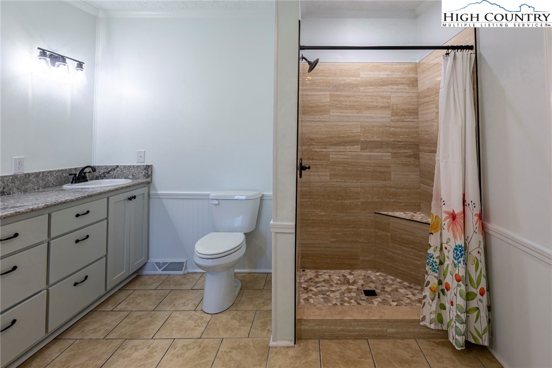 101 Beau Rivage Drive Crumpler, NC 28617 - Photo 24 of 47 a bathroom with a granite countertop toilet a sink and a shower