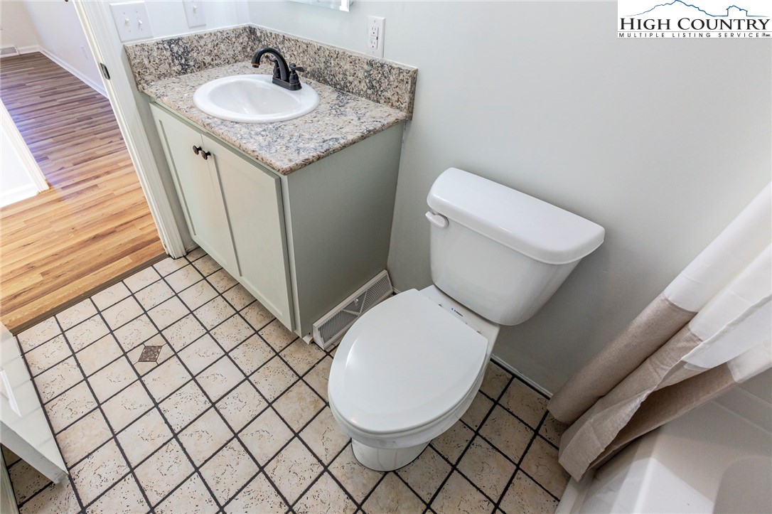 101 Beau Rivage Drive Crumpler, NC 28617 - Photo 31 of 47 a bathroom with a granite countertop toilet sink and mirror