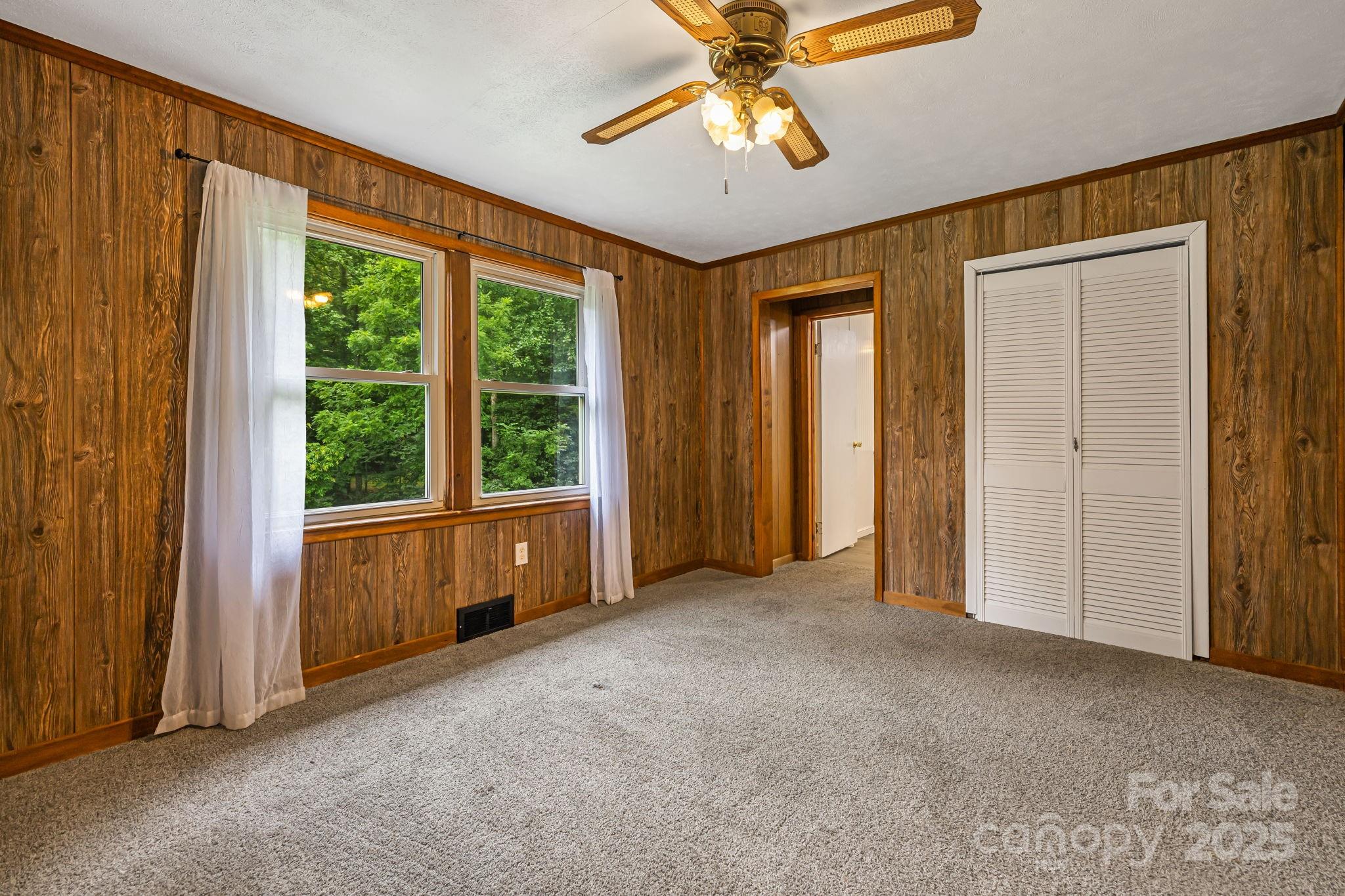 8171 Sugar Hill Road Marion, NC 28752 - Photo 17 of 27 an empty room with windows and chandelier fan
