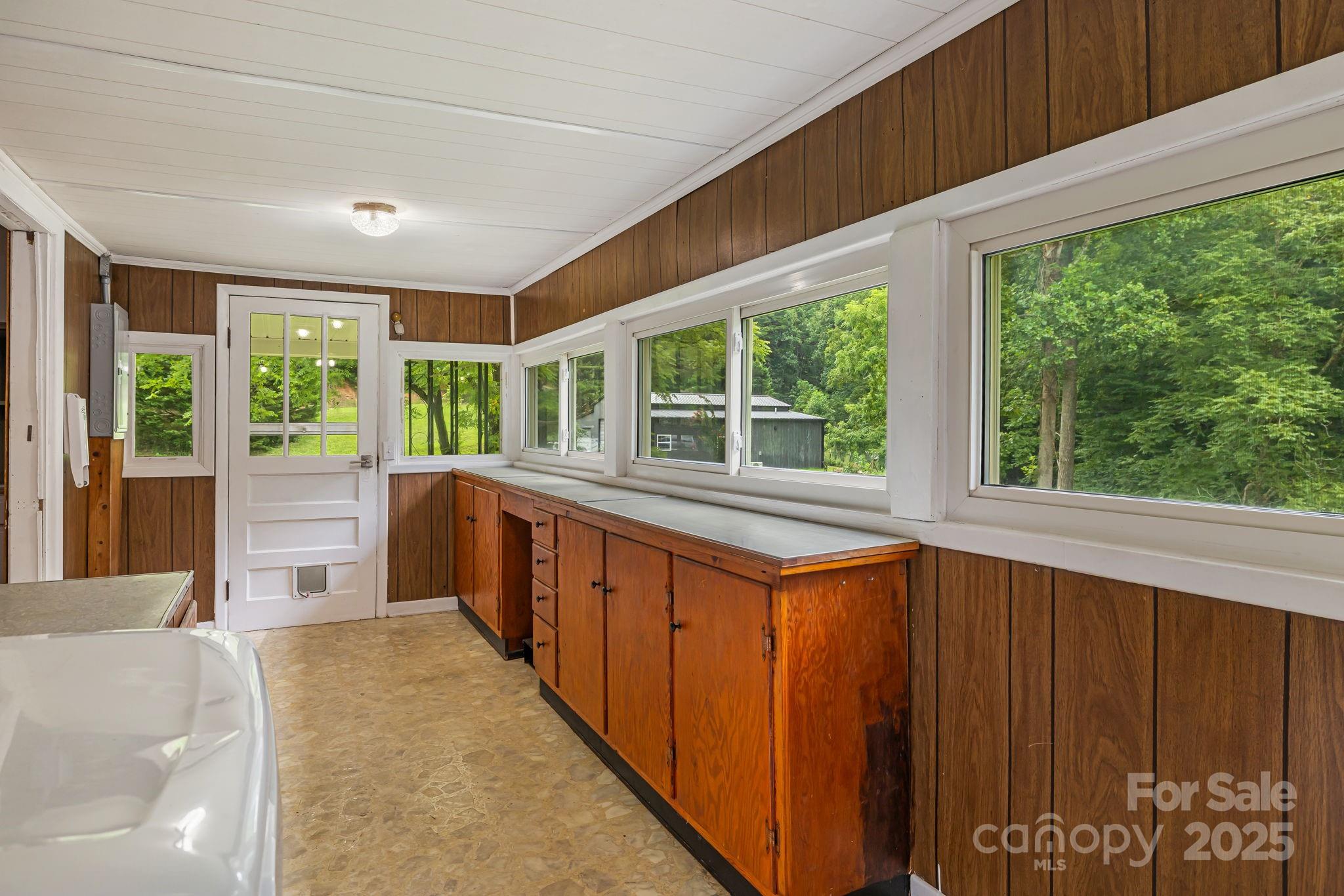 8171 Sugar Hill Road Marion, NC 28752 - Photo 26 of 27 a large white kitchen with sink and large windows