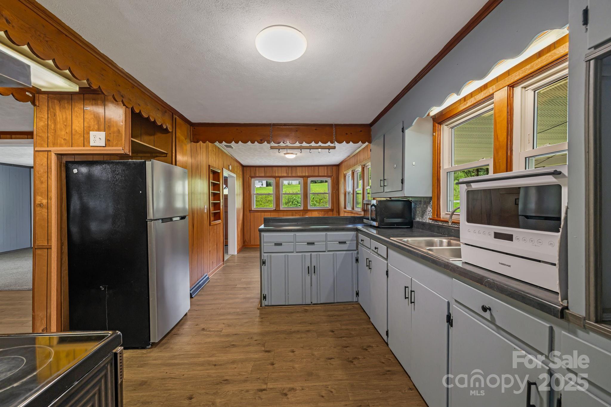 8171 Sugar Hill Road Marion, NC 28752 - Photo 4 of 27 a large kitchen with stainless steel appliances granite countertop a refrigerator a oven a sink and dishwasher with wooden floor