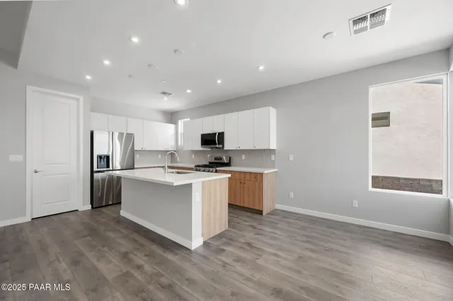 a view of a big room with wooden floor and windows