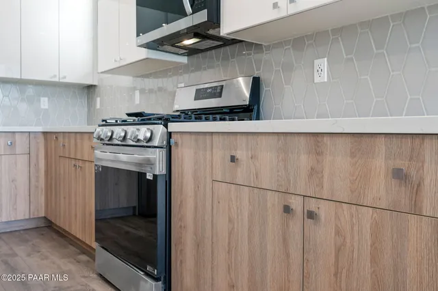 a kitchen with stainless steel appliances a stove a refrigerator a sink and cabinets