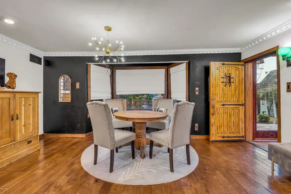 a dining room with furniture a chandelier and wooden floor