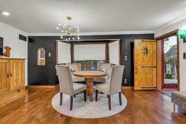 a dining room with furniture a chandelier and wooden floor