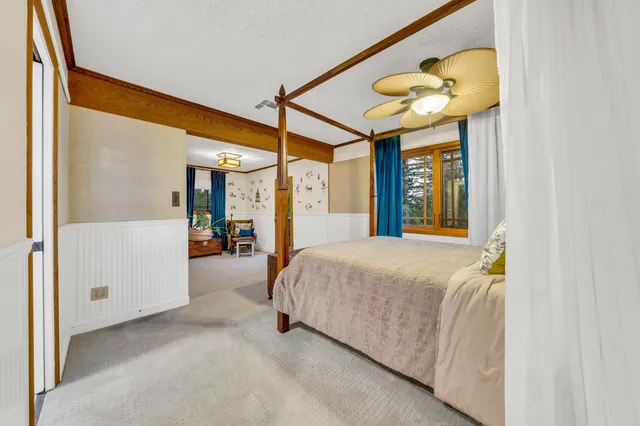 a bedroom with a large bed and a chandelier