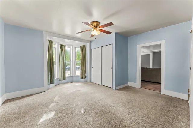 a view of a livingroom with a ceiling fan and window