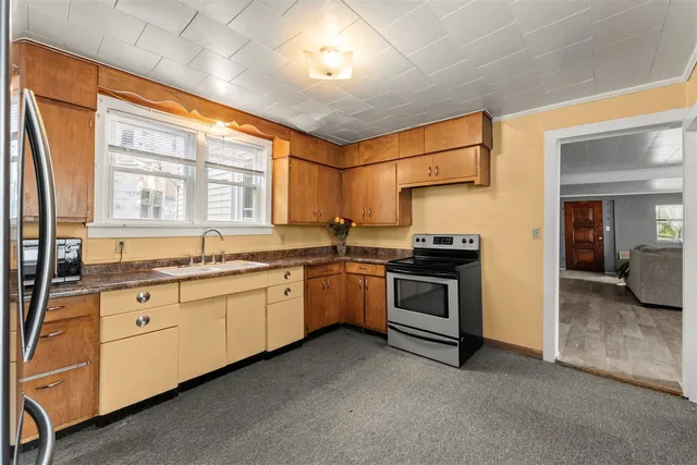 a kitchen with granite countertop a stove sink and cabinets