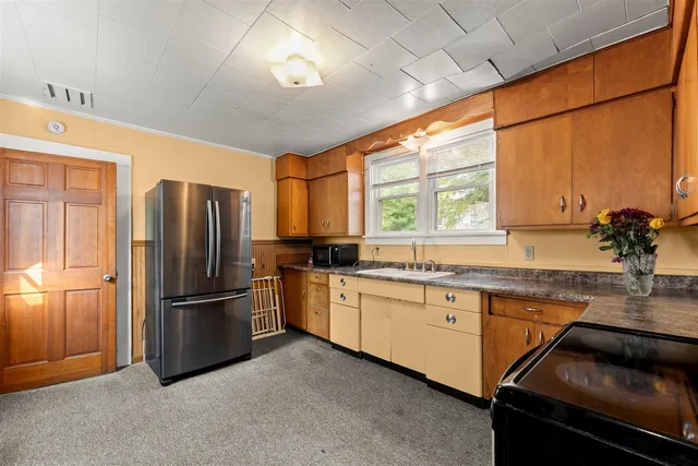 a kitchen with granite countertop stainless steel appliances a sink and a window