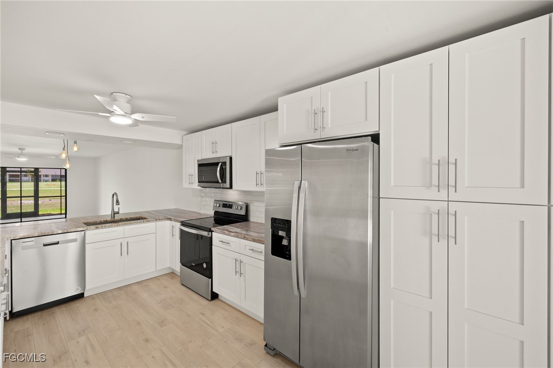 16260 Kelly Cove Drive, Unit 235 Fort Myers, FL 33908 - Photo 13 of 30 a kitchen with white cabinets and white stainless steel appliances