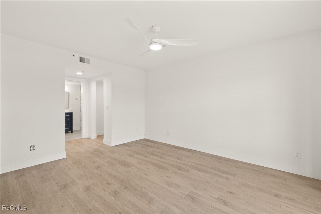 16260 Kelly Cove Drive, Unit 235 Fort Myers, FL 33908 - Photo 19 of 30 a view of an empty room with wooden floor